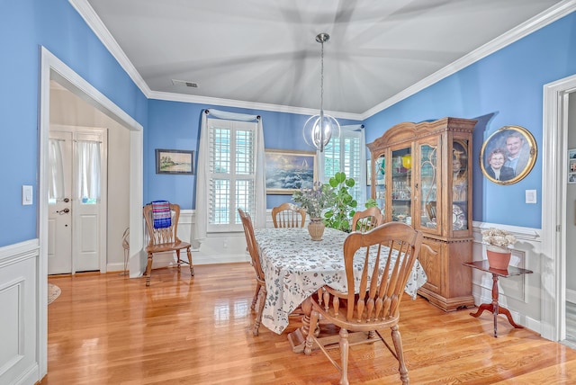 dining area featuring an inviting chandelier, crown molding, and hardwood / wood-style floors