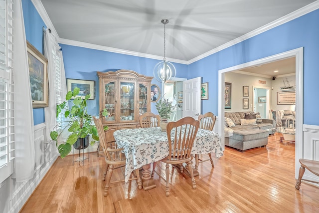 dining area with wood-type flooring, a chandelier, and ornamental molding