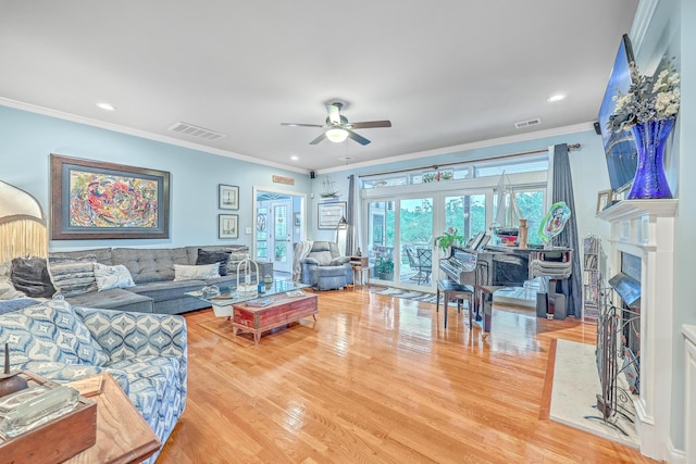 living room with hardwood / wood-style flooring, ornamental molding, and ceiling fan