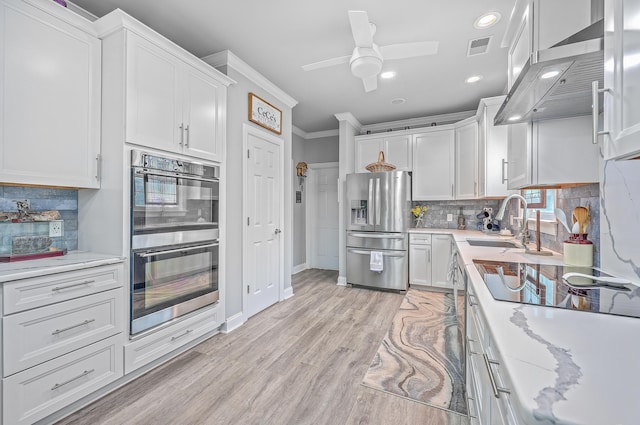 kitchen featuring extractor fan, white cabinets, ornamental molding, backsplash, and stainless steel appliances