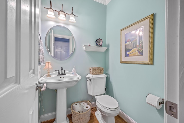 bathroom featuring sink, toilet, and ornamental molding