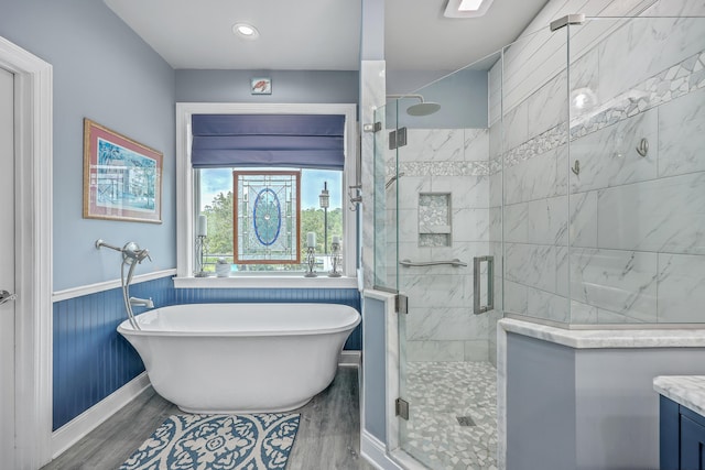 bathroom featuring hardwood / wood-style flooring, vanity, and plus walk in shower