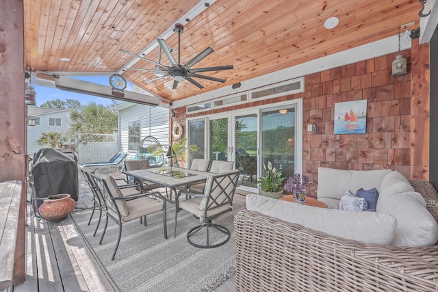 sunroom / solarium with lofted ceiling, ceiling fan, and wood ceiling