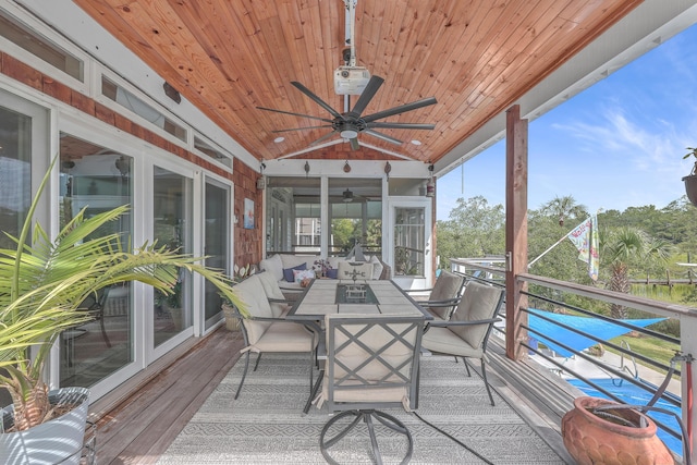 sunroom / solarium featuring ceiling fan, wooden ceiling, and lofted ceiling