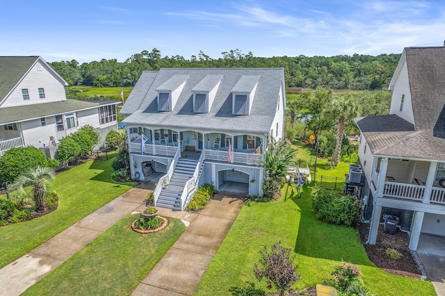 coastal inspired home with central AC, a front lawn, a porch, and a carport