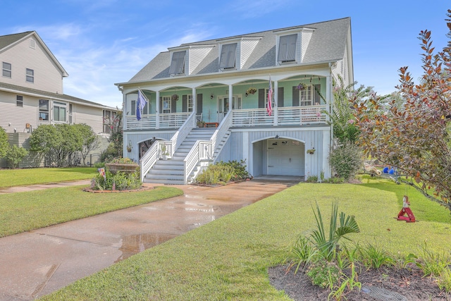 view of front of house with covered porch, a front yard, and a garage