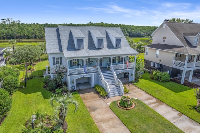 view of front of house with covered porch, a front yard, and a garage