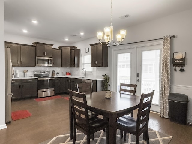dining room featuring dark wood-type flooring, a chandelier, and recessed lighting