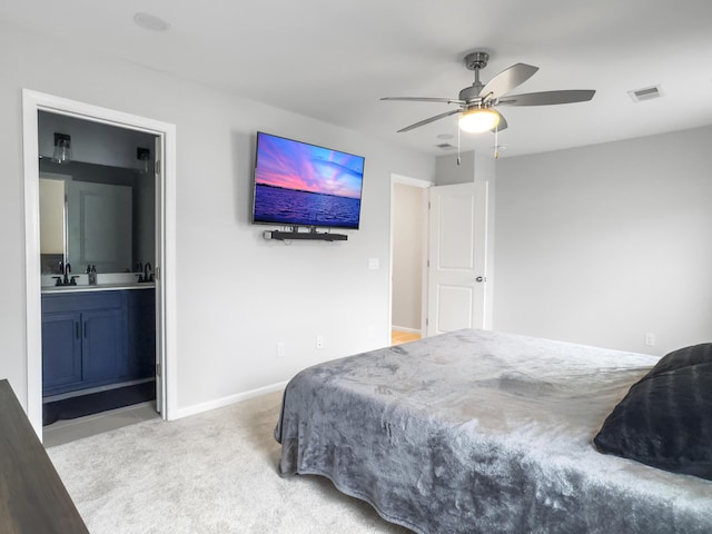 bedroom with a sink, carpet floors, baseboards, connected bathroom, and a ceiling fan