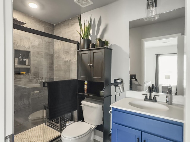 full bath with toilet, vanity, and a stall shower