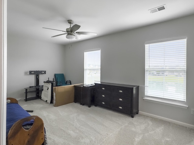office area with light colored carpet, a ceiling fan, and baseboards
