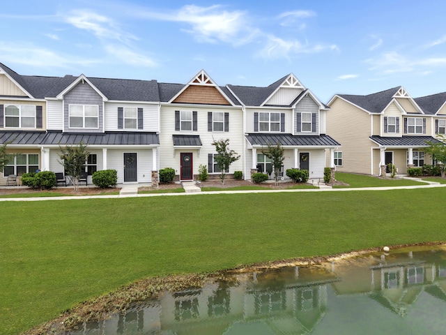townhome / multi-family property featuring a standing seam roof, metal roof, and a front lawn