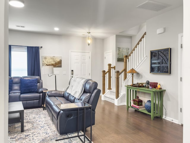 living area featuring baseboards, wood finished floors, stairs, and recessed lighting
