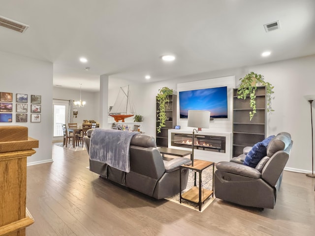living room with hardwood / wood-style floors, recessed lighting, a glass covered fireplace, and baseboards