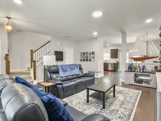 living area featuring dark wood-style flooring, stairs, baseboards, and recessed lighting