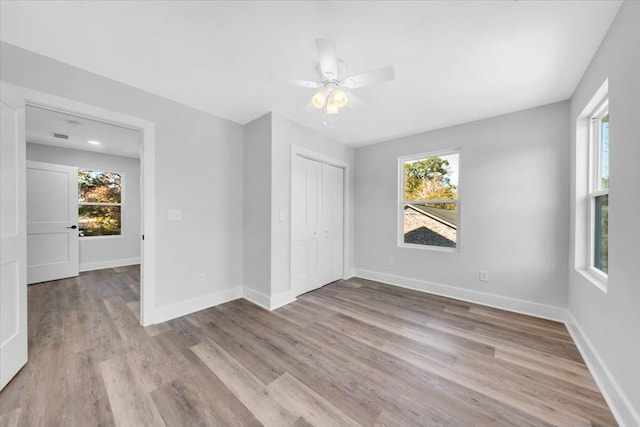 empty room with light wood-type flooring, ceiling fan, and plenty of natural light