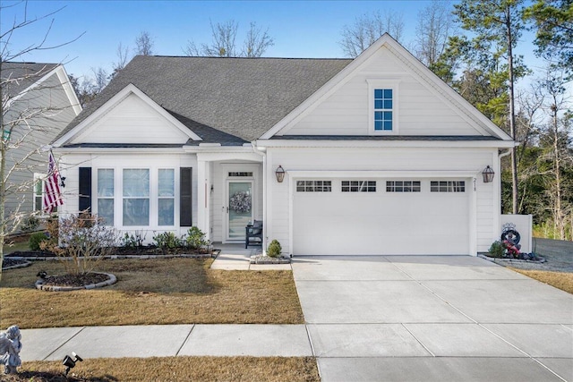 view of front of home featuring concrete driveway, a garage, a front yard, and a shingled roof