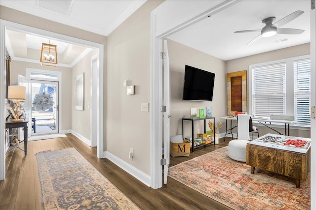 entrance foyer featuring baseboards, crown molding, wood finished floors, a ceiling fan, and a chandelier