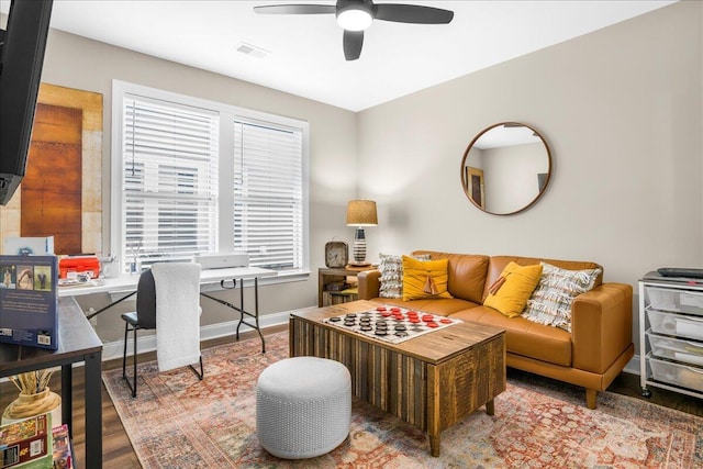 living area featuring ceiling fan, wood finished floors, and baseboards