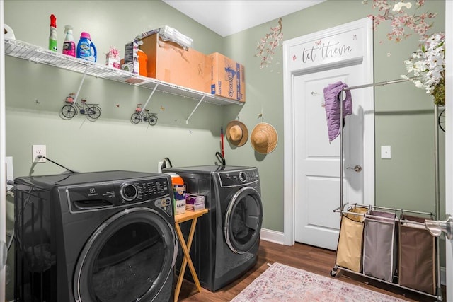 washroom with washing machine and clothes dryer, dark wood finished floors, and baseboards