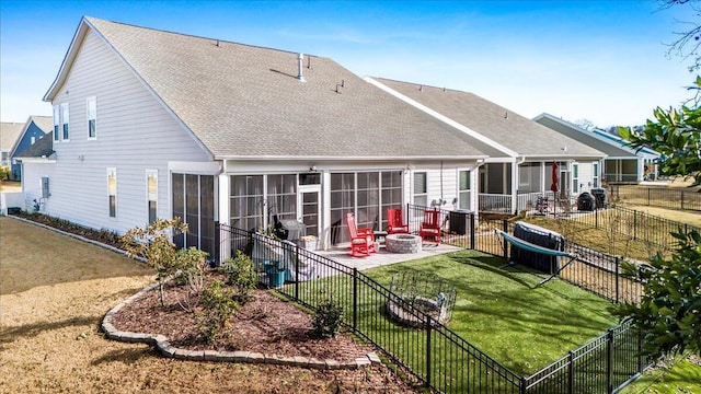 back of house featuring a sunroom, a patio, a fire pit, and a shingled roof