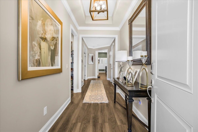 hallway with dark wood-style floors, baseboards, and ornamental molding