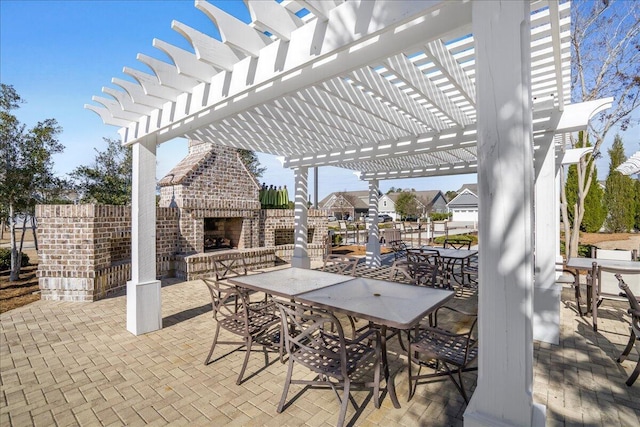 view of patio featuring an outdoor brick fireplace and a pergola