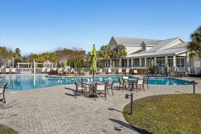 community pool with fence and a patio area