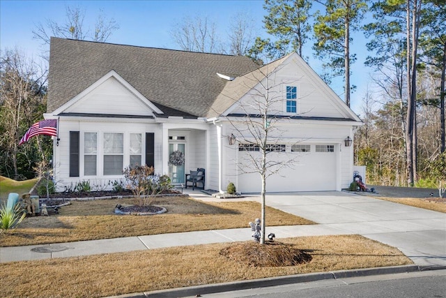 view of front of home featuring an attached garage, driveway, a front yard, and a shingled roof