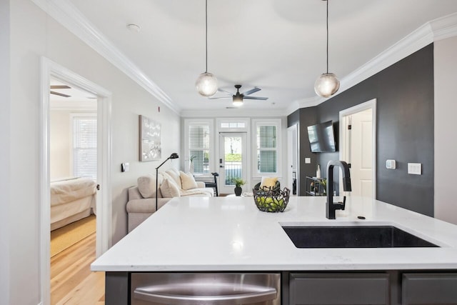 kitchen featuring crown molding, sink, and hanging light fixtures