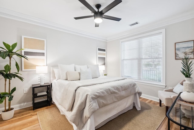 bedroom with hardwood / wood-style floors, crown molding, and ceiling fan