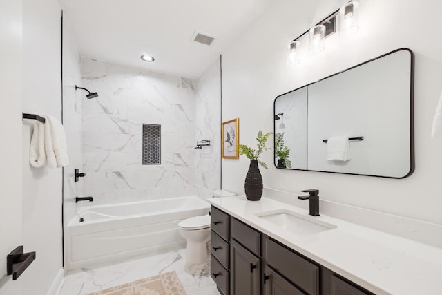 full bathroom featuring tiled shower / bath, vanity, and toilet