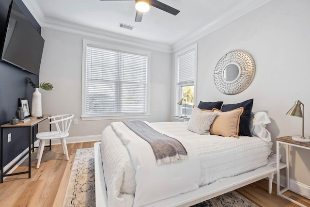 bedroom featuring ceiling fan, ornamental molding, and light wood-type flooring