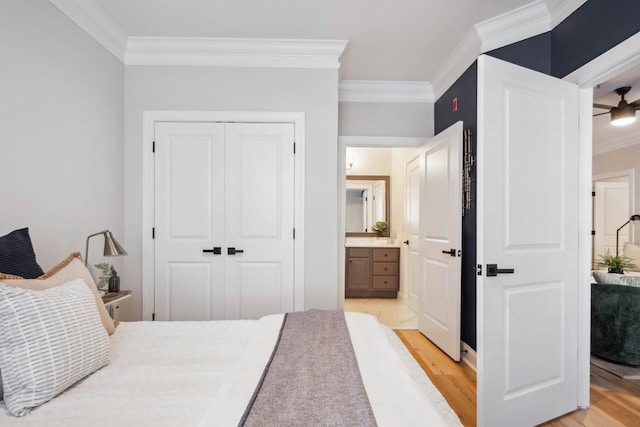 bedroom featuring crown molding, a closet, and light hardwood / wood-style flooring