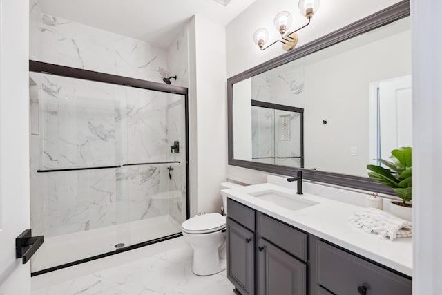 bathroom featuring a shower with door, vanity, and toilet