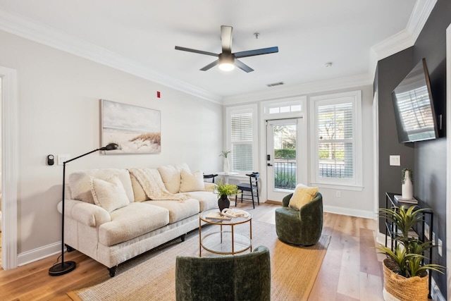 living room featuring ceiling fan, ornamental molding, and light hardwood / wood-style flooring