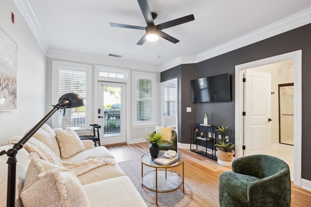 living room featuring crown molding, ceiling fan, and light wood-type flooring