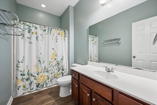 bathroom featuring vanity, wood-type flooring, and toilet