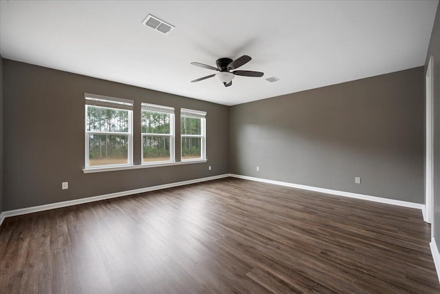 spare room with dark wood-type flooring and ceiling fan