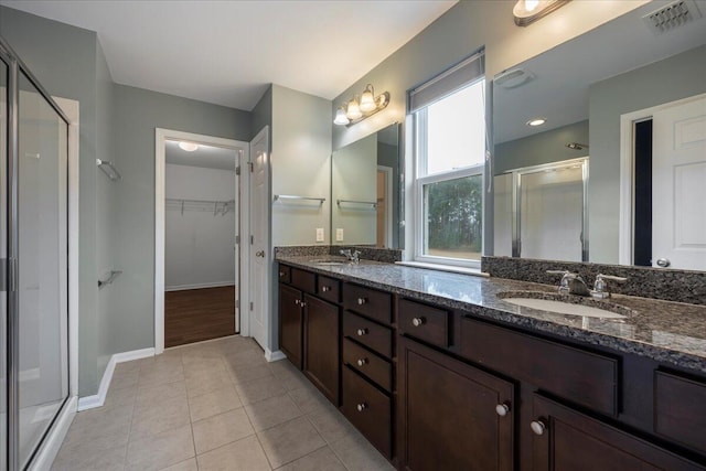 bathroom featuring tile patterned flooring, vanity, and a shower with shower door