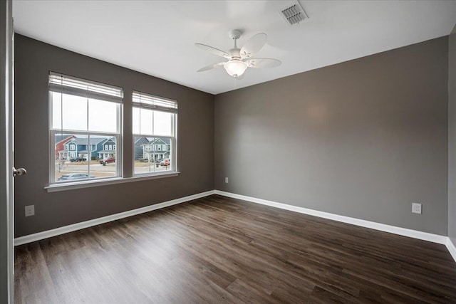 empty room with ceiling fan and dark hardwood / wood-style flooring