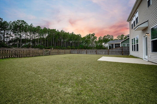 yard at dusk featuring a patio