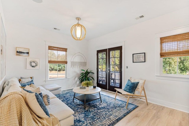 living room with french doors, light hardwood / wood-style flooring, and a wealth of natural light