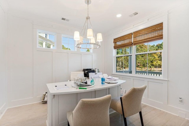 dining area featuring light wood-type flooring and a chandelier