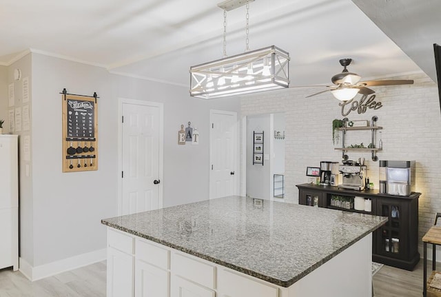 49 Auld Brass Rd, Walterboro, SC 29488 - kitchen featuring a ceiling fan, light wood-style floors, dark stone countertops, white cabinetry, and a kitchen island