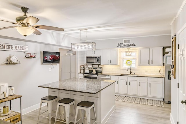 49 Auld Brass Rd, Walterboro, SC 29488 - kitchen featuring stainless steel appliances, a sink, backsplash, a breakfast bar area, and a center island