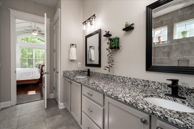 bathroom with a sink, double vanity, a ceiling fan, and tile patterned floors