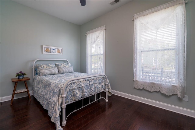 bedroom featuring visible vents, ceiling fan, baseboards, and wood finished floors