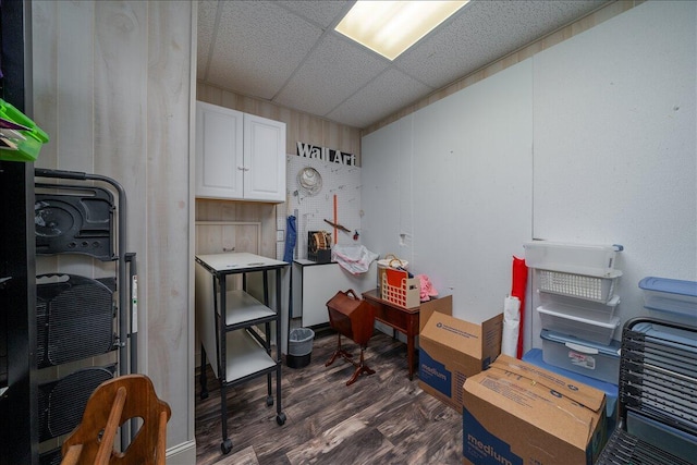 interior space with a drop ceiling and dark wood-style floors