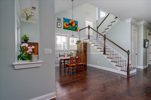 dining space with baseboards, a chandelier, stairs, a towering ceiling, and wood finished floors